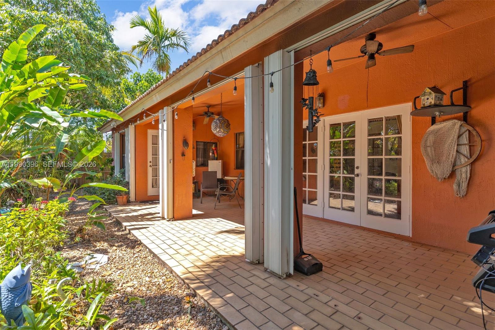 15012 Southwest 45th Lane Miami, FL 33185 - Photo 26 of 43 a view of a porch with a floor to ceiling window and potted plants