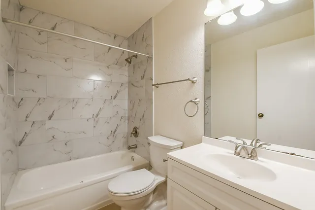a bathroom with a sink toilet vanity and shower