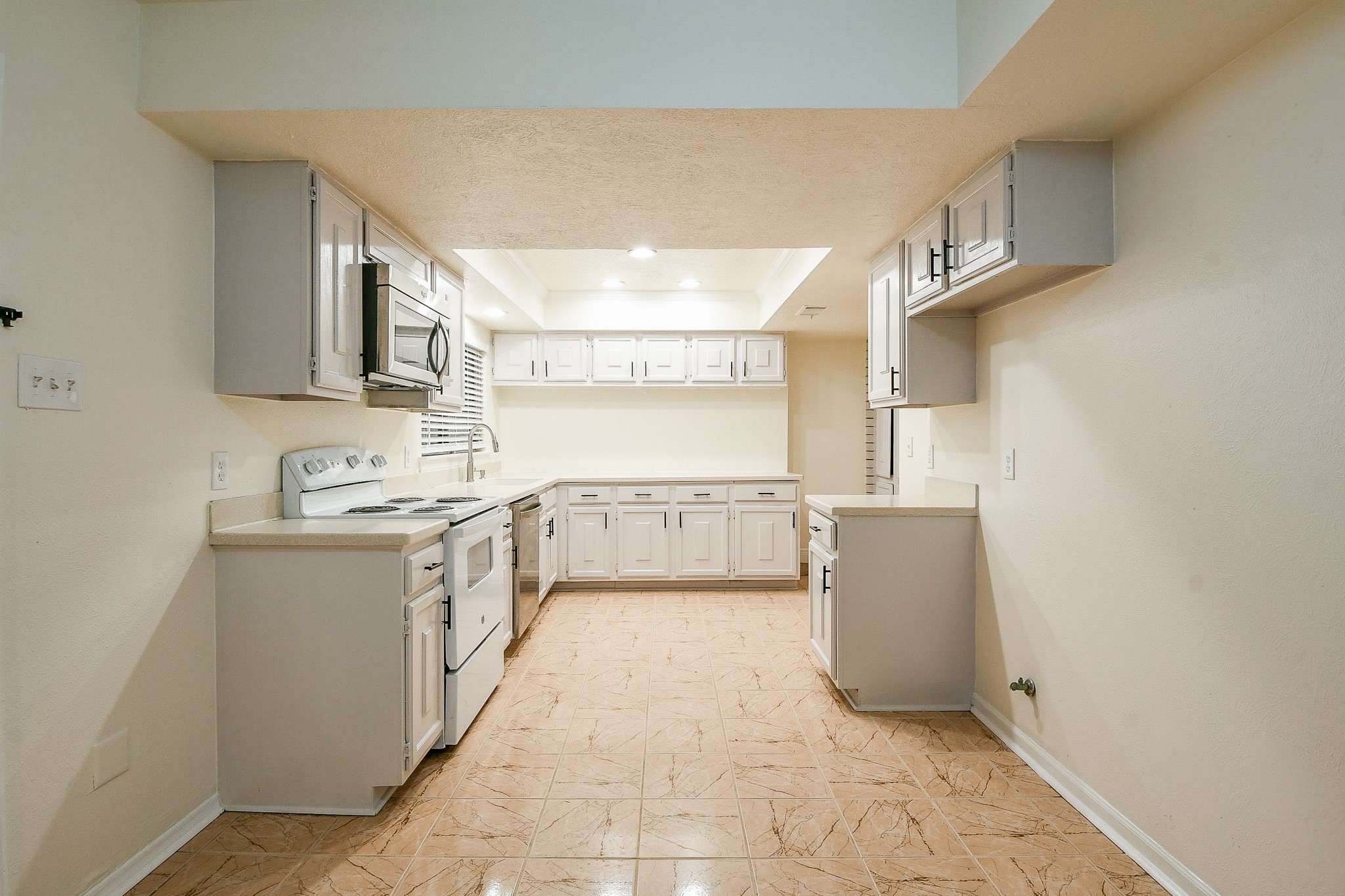 26 Yewleaf Road The Woodlands, TX 77381 - Photo 7 of 21 a large kitchen with a stove a sink dishwasher and a refrigerator