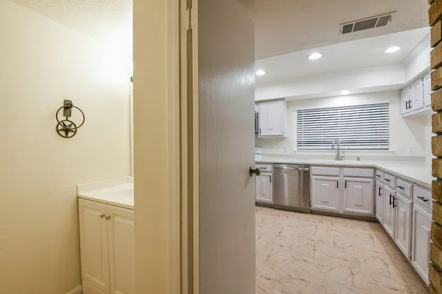 a large bathroom with a granite countertop sink a washer and dryer