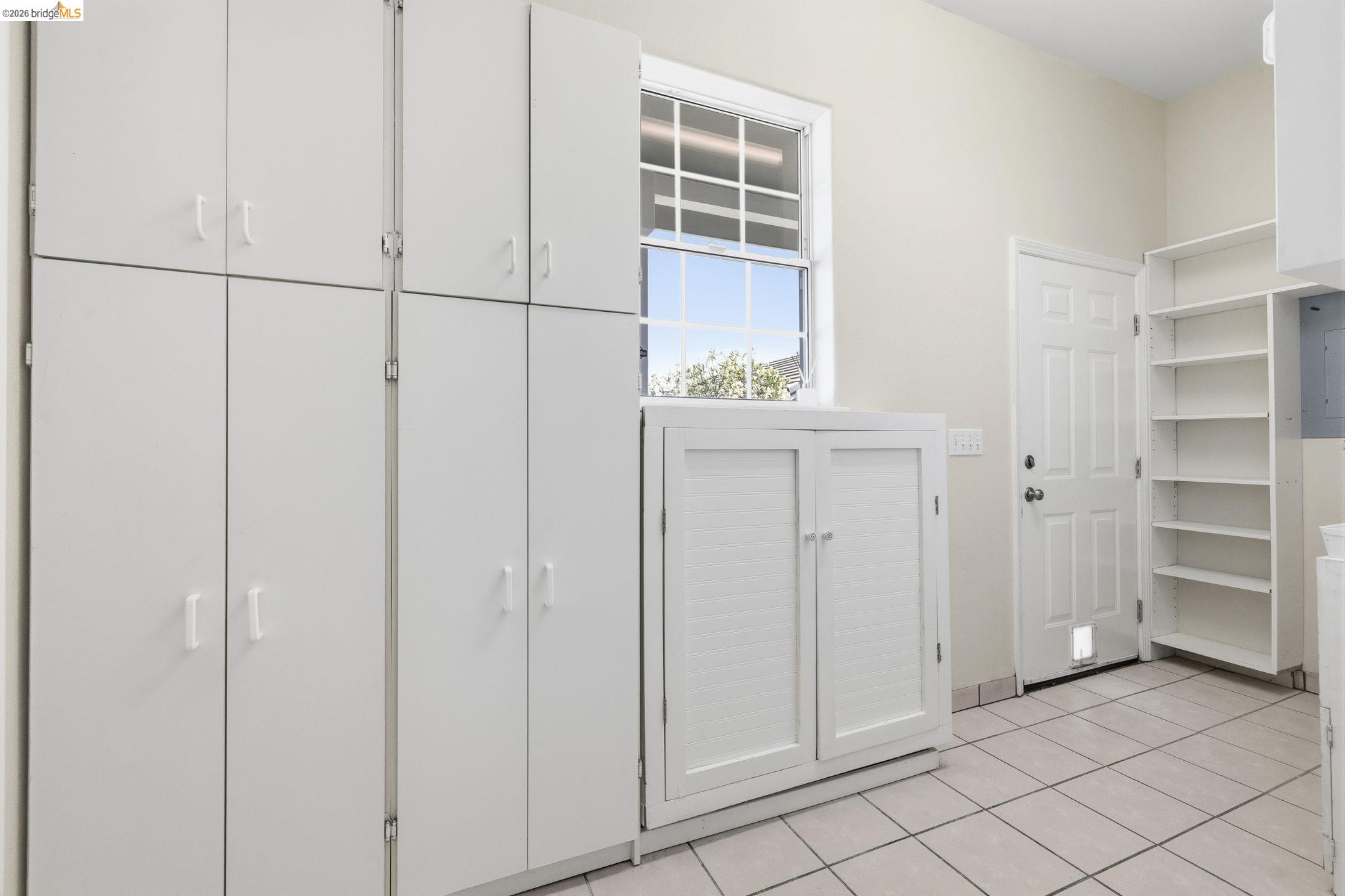 6242 Bluff View Road Copperopolis, CA 95228 - Photo 23 of 59 Dedicated utility space just off the kitchen with exterior door leading to garage featuring extensive white cabinetry for housing all your lake toys and supplies