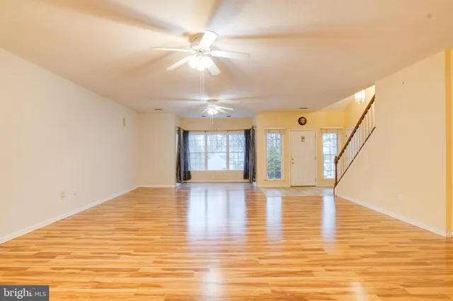 a kitchen with stainless steel appliances granite countertop a refrigerator a stove top oven a sink with wooden floors and large closet