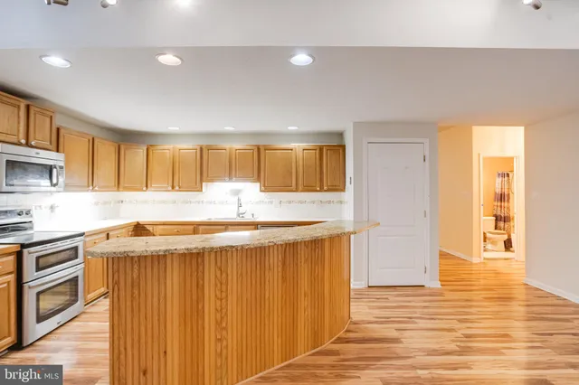 a kitchen with stainless steel appliances granite countertop a sink stove and cabinets