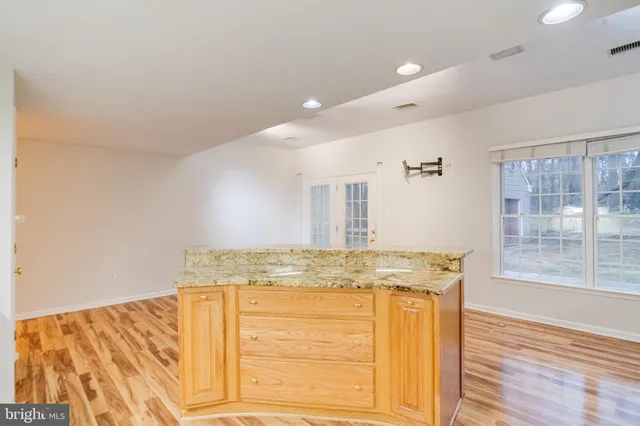 a view of an empty room with window and a chandelier fan