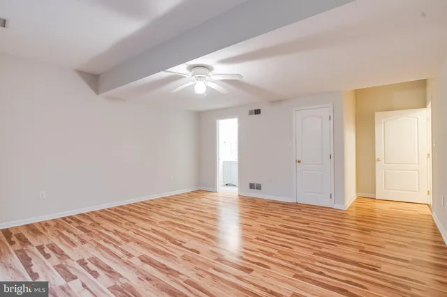 a view of empty room with window and wooden floor