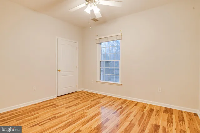 an empty room with chandelier fan