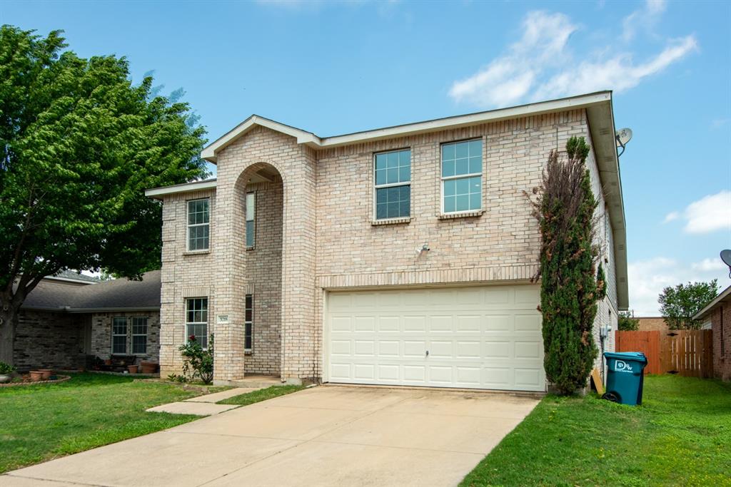 5718 Green Ivy Road Denton, TX 76210 - Photo 33 of 37 Two-story brick facade residence featuring an arched entryway, an attached two-car garage, and a concrete driveway