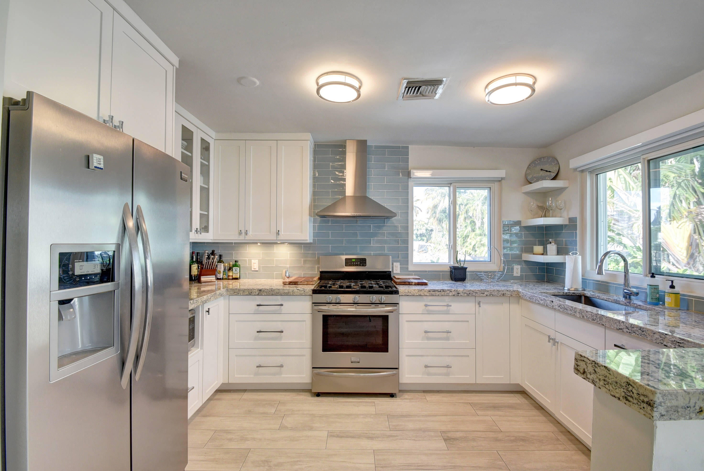 a kitchen with stainless steel appliances granite countertop a stove a refrigerator and a sink