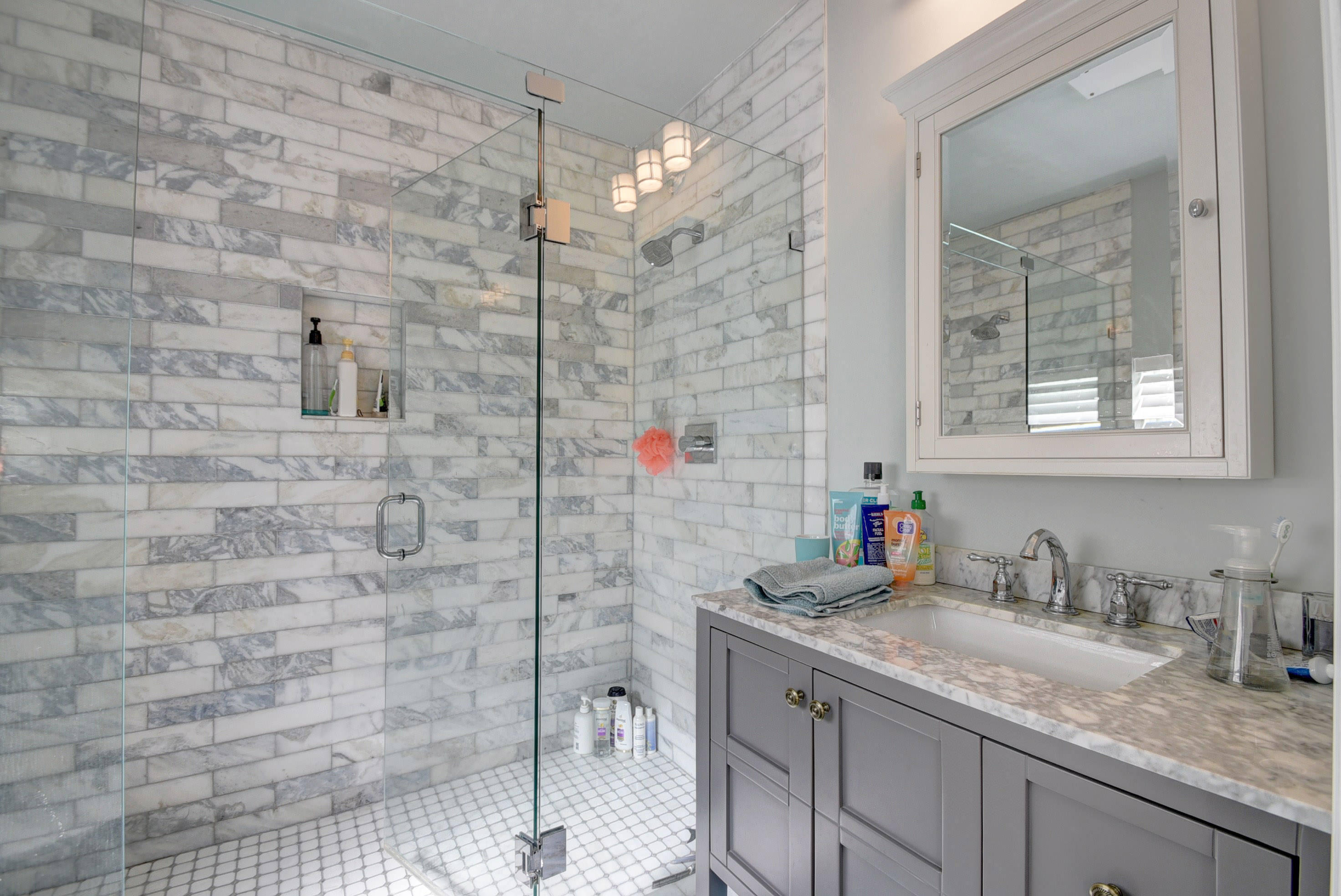 1020 Casuarina Road Delray Beach, FL 33483 - Photo 9 of 17 a bathroom with a granite countertop sink a mirror and a shower