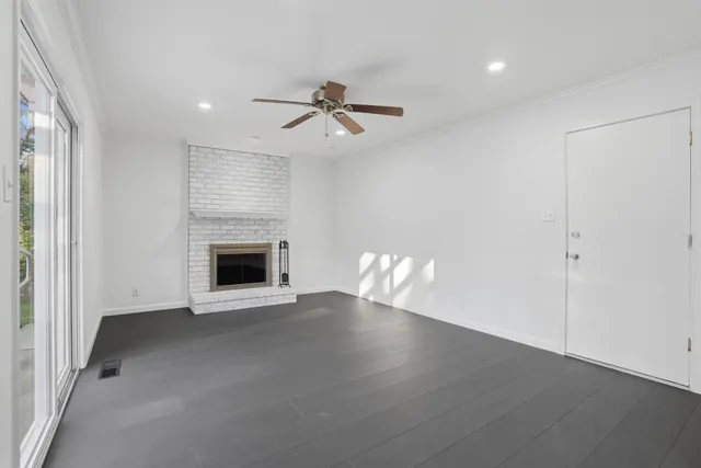 an empty room with windows and fireplace