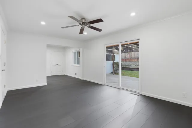 an empty room with a window and a fan