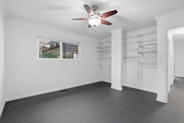 an empty room with closet and windows