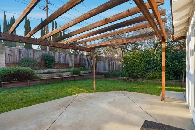 a view of a backyard with potted plants and wooden fence