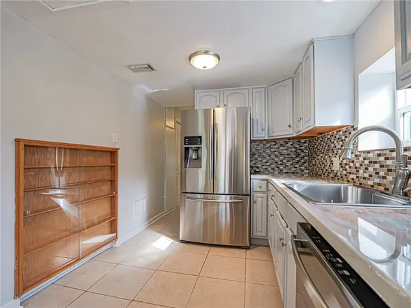 a kitchen with granite countertop a refrigerator and a sink