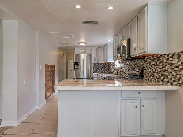 a kitchen with kitchen island granite countertop a sink and cabinets