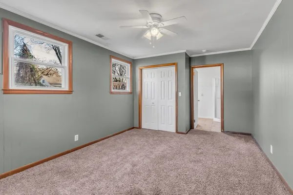 an empty room with windows and fan