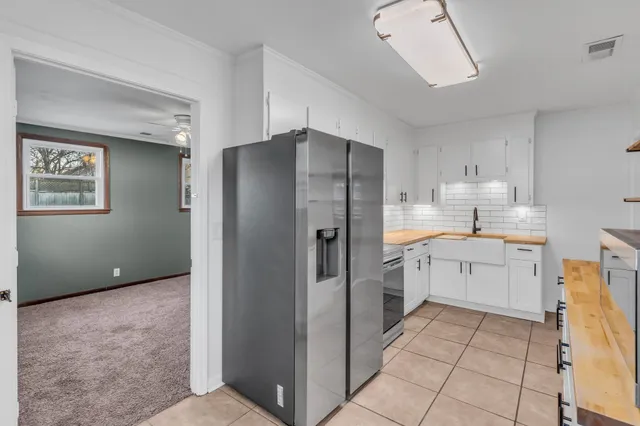 a kitchen with a refrigerator sink and cabinets