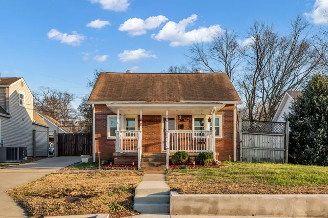 a view of a white house with large windows and a tree