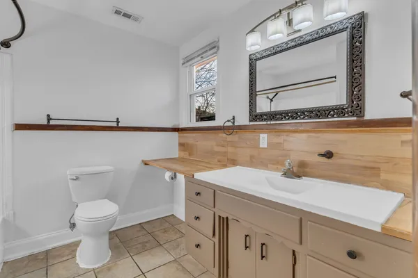 a bathroom with a sink a toilet and mirror