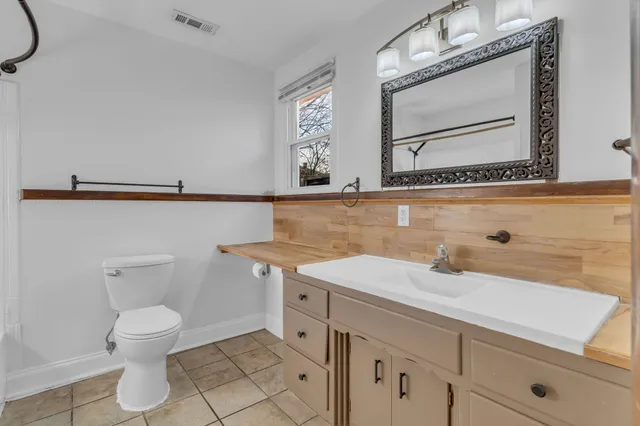 a bathroom with a sink a toilet and mirror