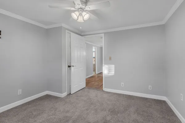 a view of an empty room with a chandelier fan
