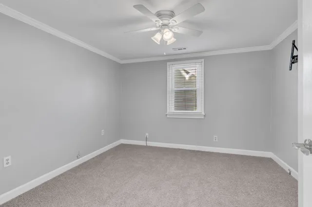 an empty room with a window and a fan