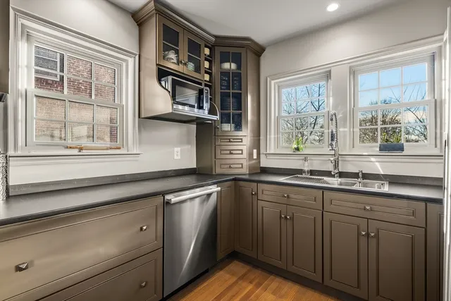a kitchen with stainless steel appliances granite countertop a sink and wooden cabinets