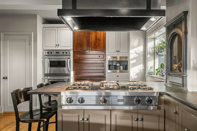 a view of kitchen with stainless steel appliances granite countertop a stove and a sink