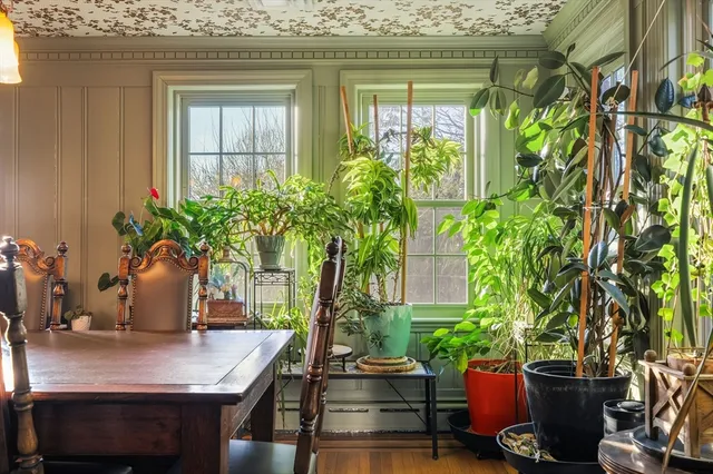 a vase of flowers sitting on a table in front of a house