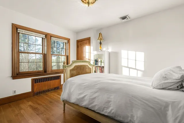 a bedroom with a bed and wooden floor