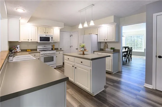 a view of a room with a ceiling fan and hardwood floor