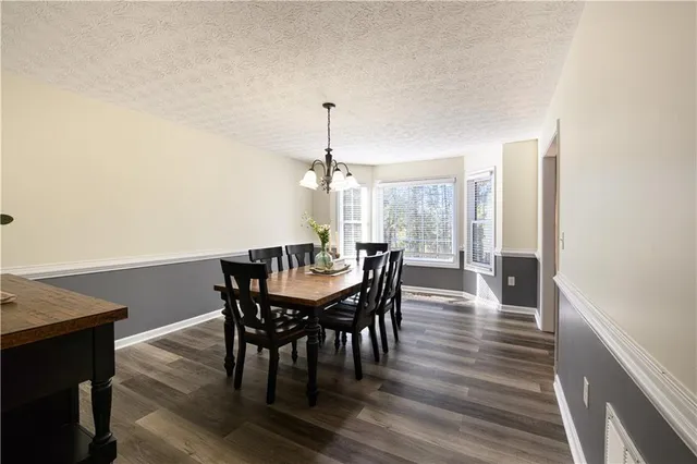a view of an empty room with wooden floor and window