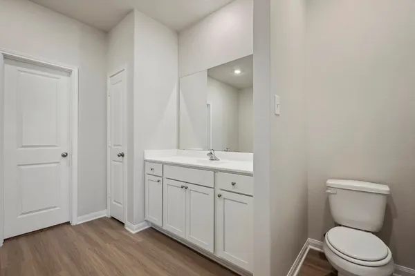 a bathroom with a toilet a sink and mirror
