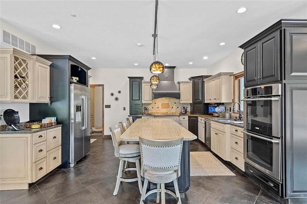 1860 Eastbrook Road New Castle, PA 16101 - Photo 12 of 25 a large kitchen with stainless steel appliances kitchen island granite countertop a table chairs and a refrigerator