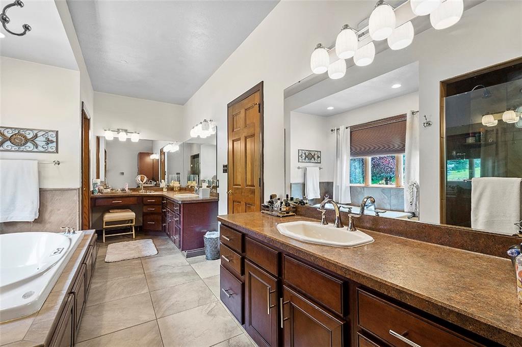 1860 Eastbrook Road New Castle, PA 16101 - Photo 15 of 25 a spacious bathroom with a granite countertop sink a large mirror and a bathtub