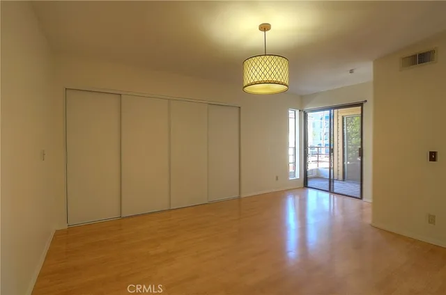 a view of empty room with a chandelier fan and a bathroom