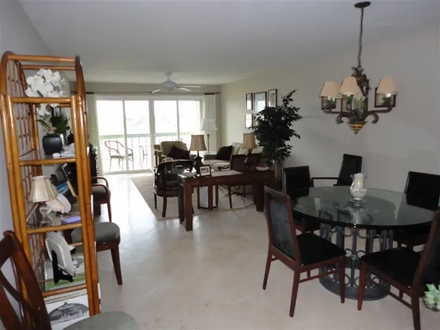 a view of a dining room and livingroom with furniture wooden floor a chandelier