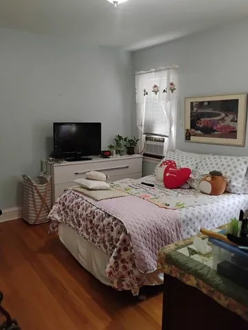 a bedroom with a bed and wooden floor