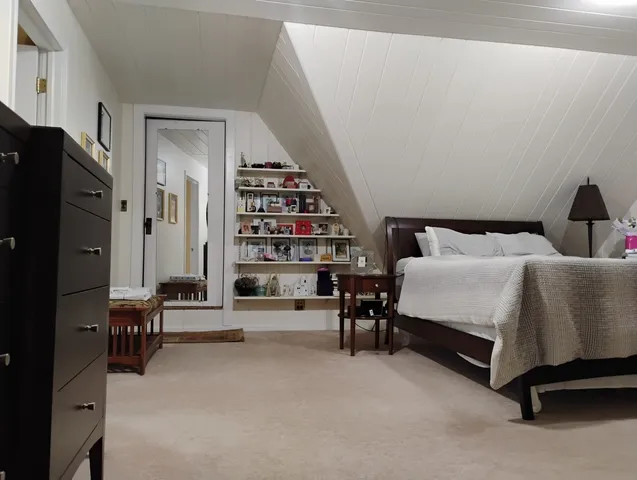 a bedroom with furniture and a large window