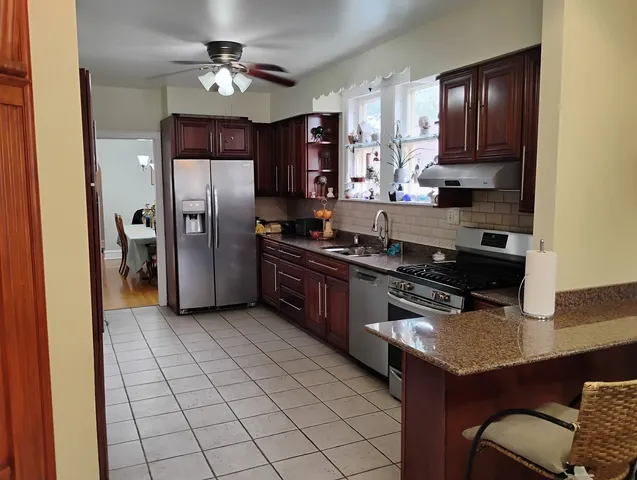 a kitchen with stainless steel appliances granite countertop a refrigerator a stove and a cabinets