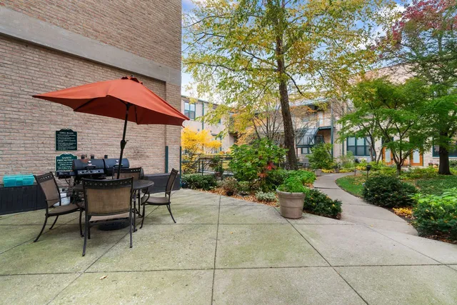 a view of a patio with a table and chairs under an umbrella