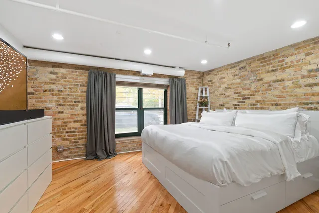 a bedroom with a large bed and a flat tv screen