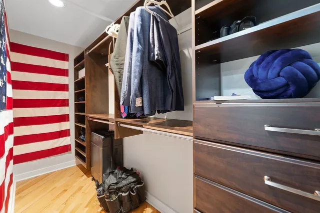 a view of walk in closet with clothes and shoes