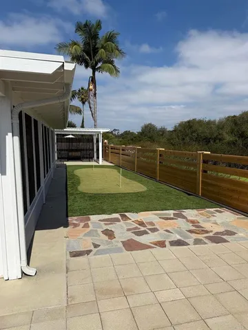 a view of a house with a patio and a yard