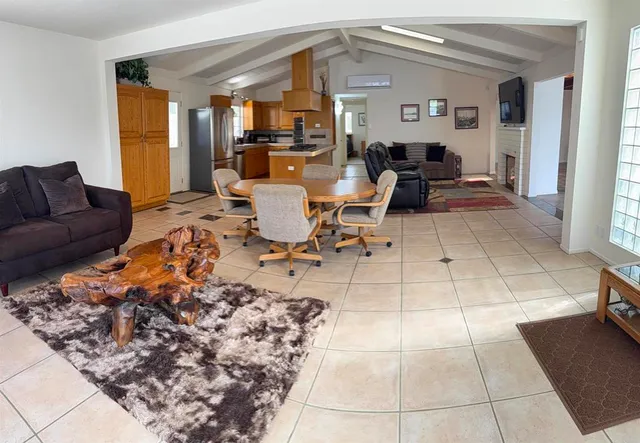 a living room with furniture a dining table and a large window