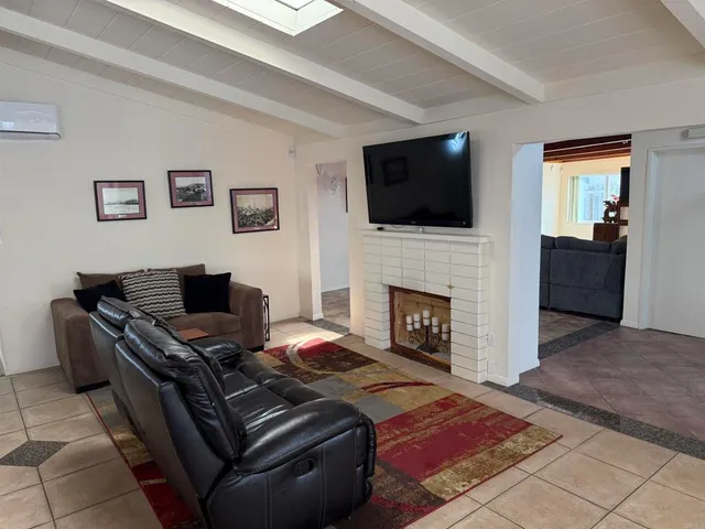 a living room with furniture a flat screen tv and a fireplace