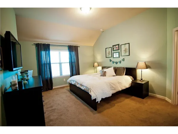 a bedroom with a bed and a lamp