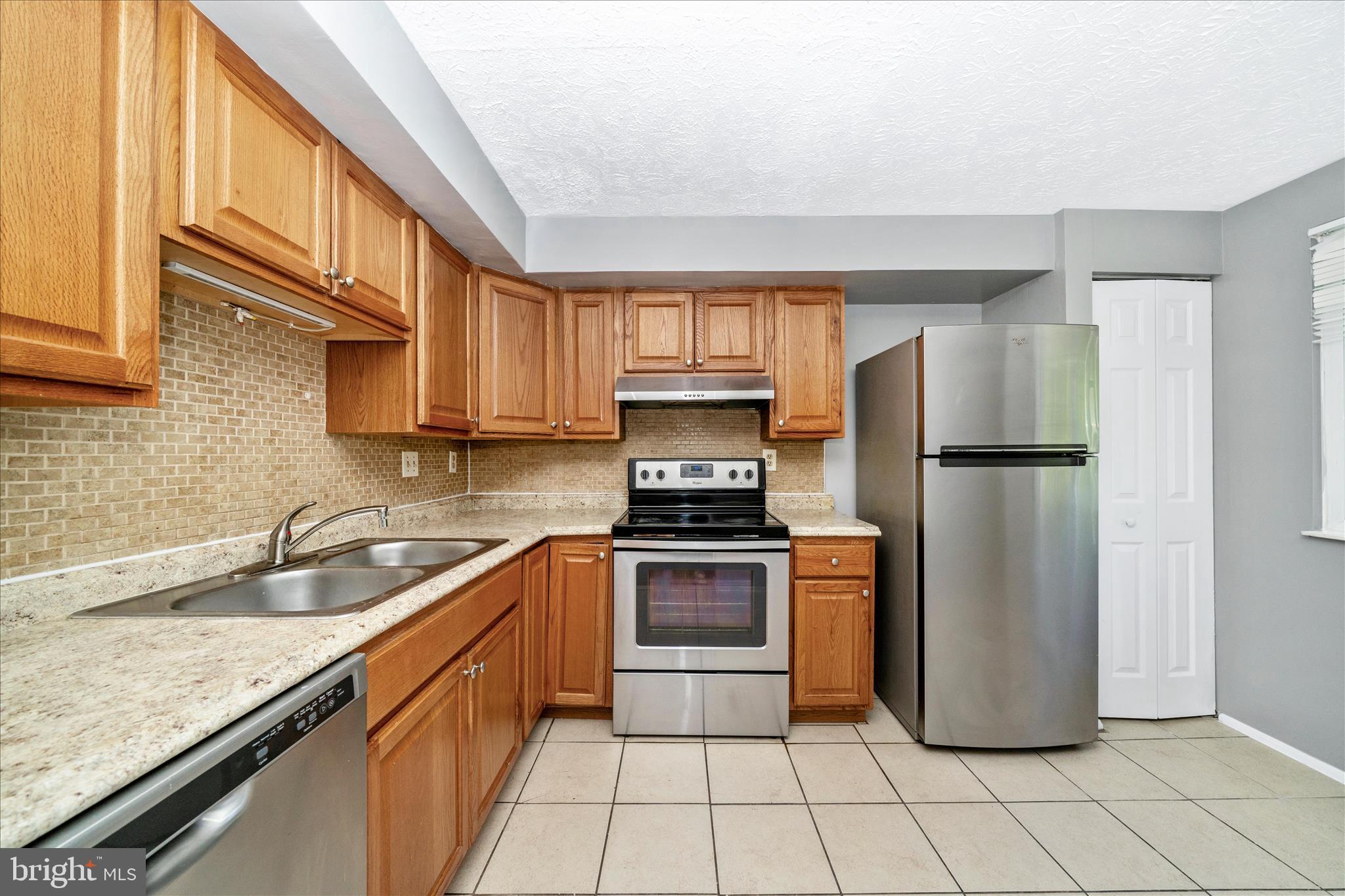 3749 Castle Terrace, Unit 12114 Silver Spring, MD 20904 - Photo 17 of 51 a kitchen with a refrigerator sink and cabinets