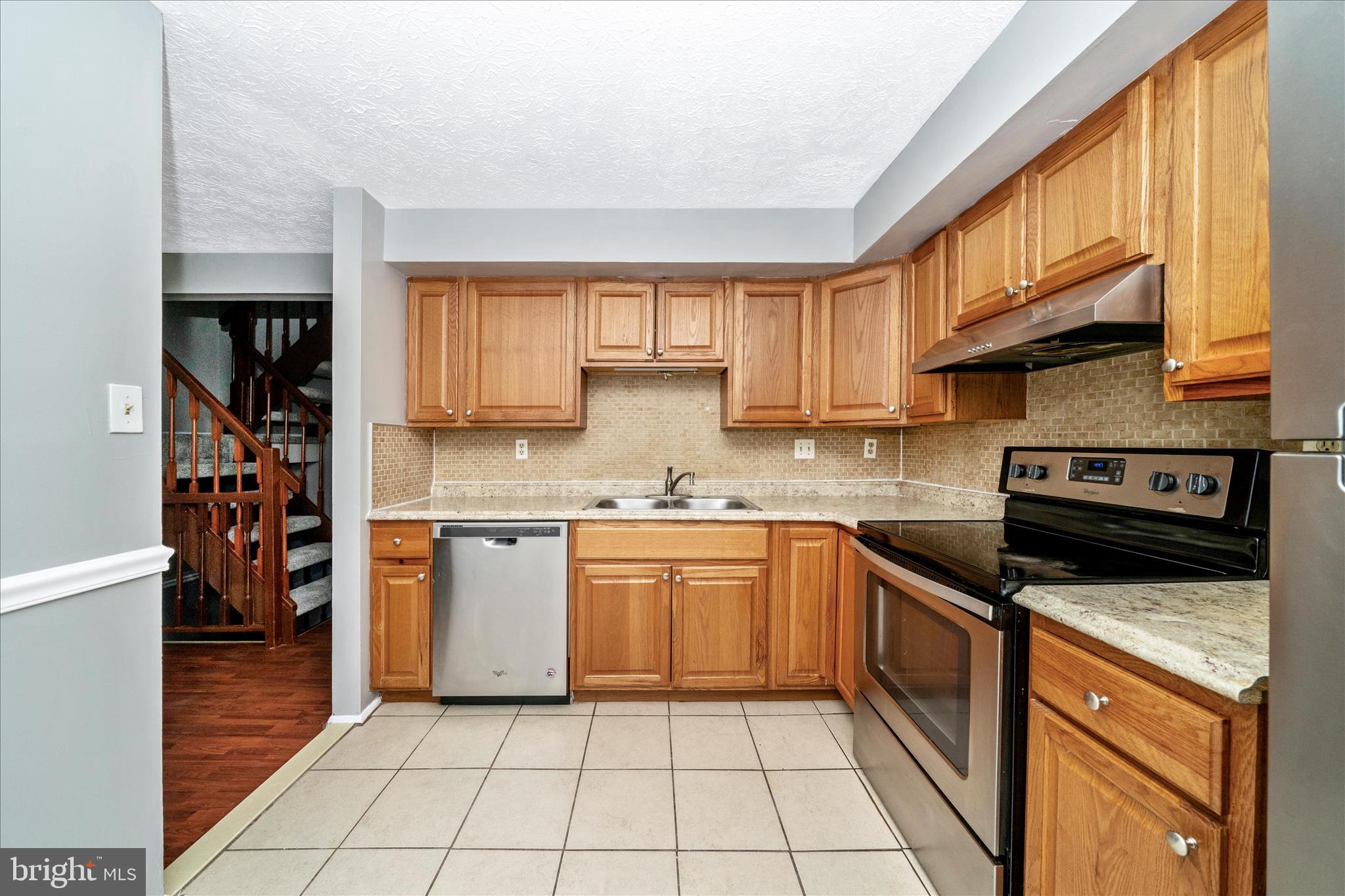 3749 Castle Terrace, Unit 12114 Silver Spring, MD 20904 - Photo 18 of 51 a kitchen with stainless steel appliances granite countertop a stove a sink and a microwave