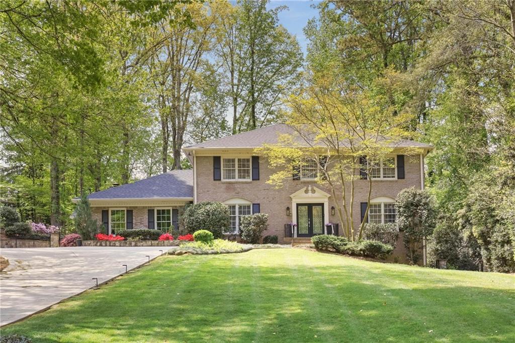 a front view of a house with yard and green space